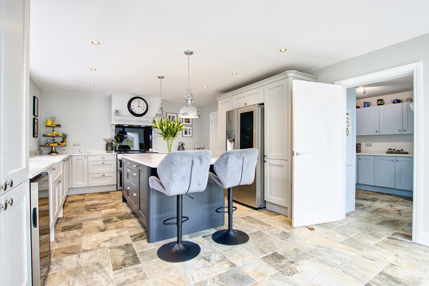 Farmhouse kitchen with dark blue contrasting island 