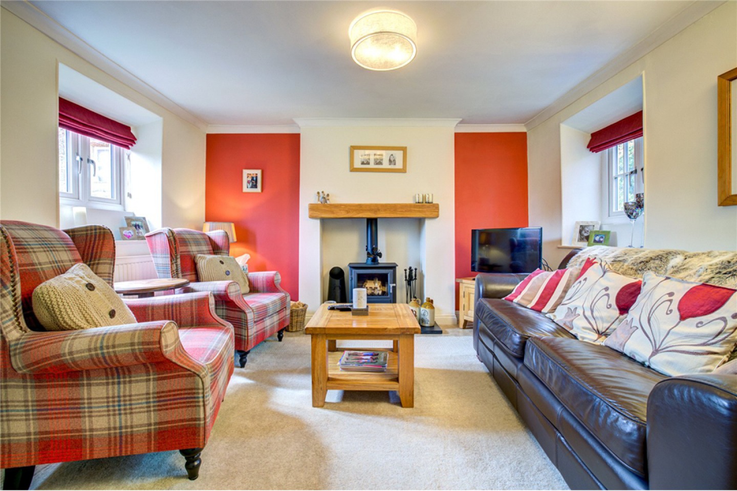 Lounge with wood burning stove and warm orange colours