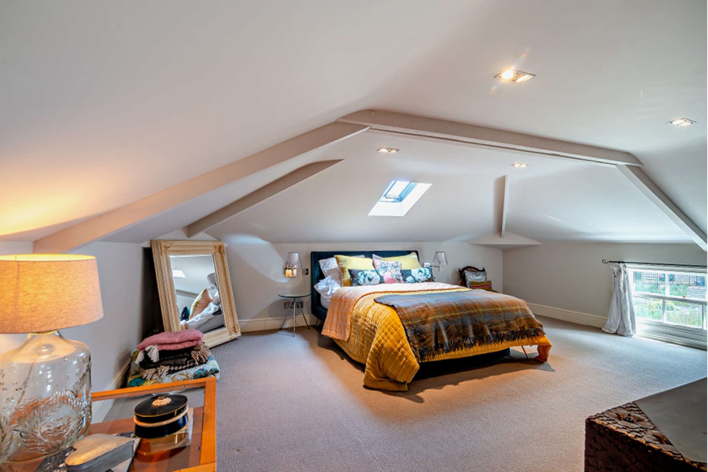 Bedroom in converted loft space with low windows 