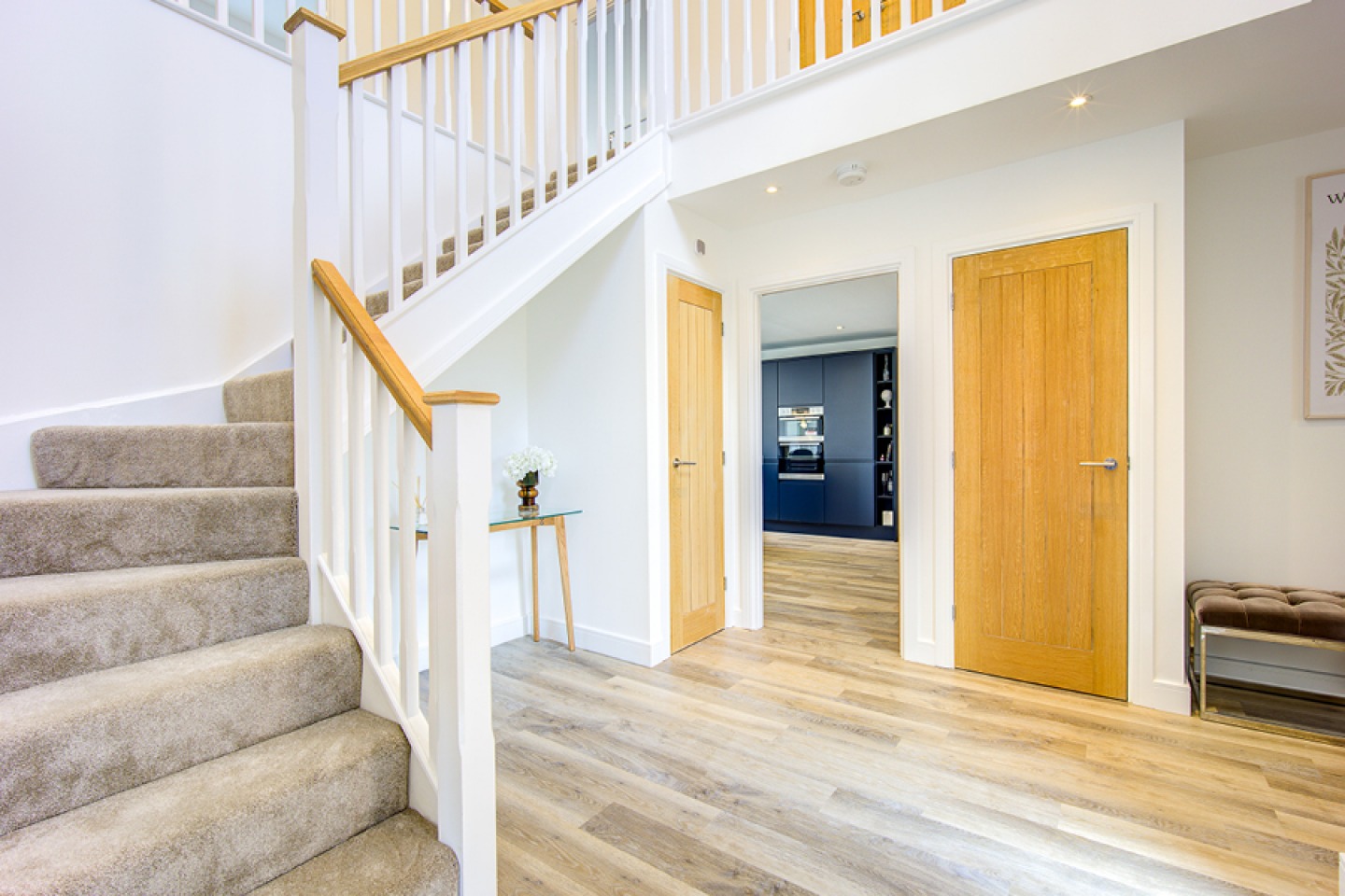 Large hallway with oak doors and open staircase