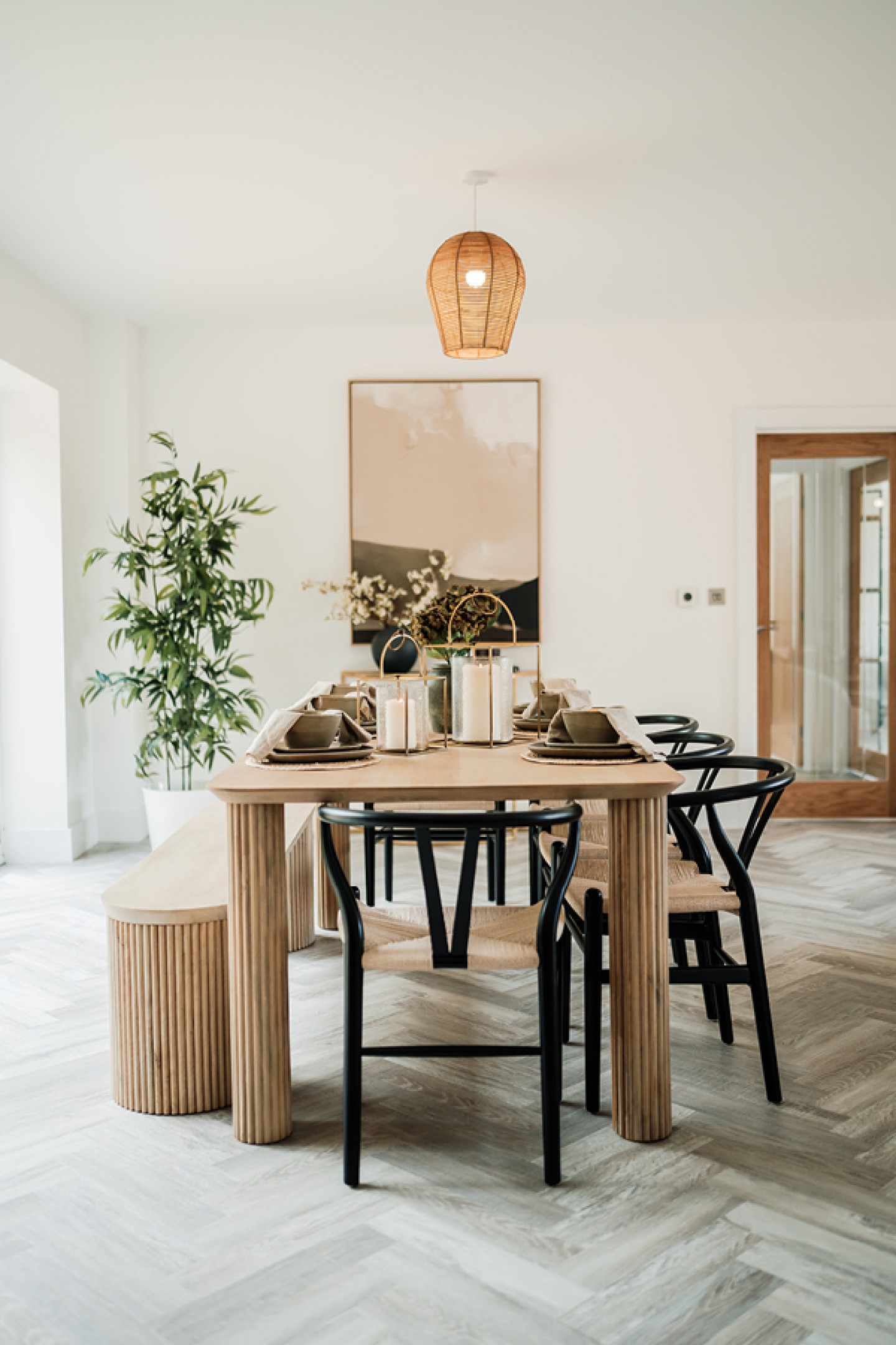 Contemporary set dining table with a large plant in the background