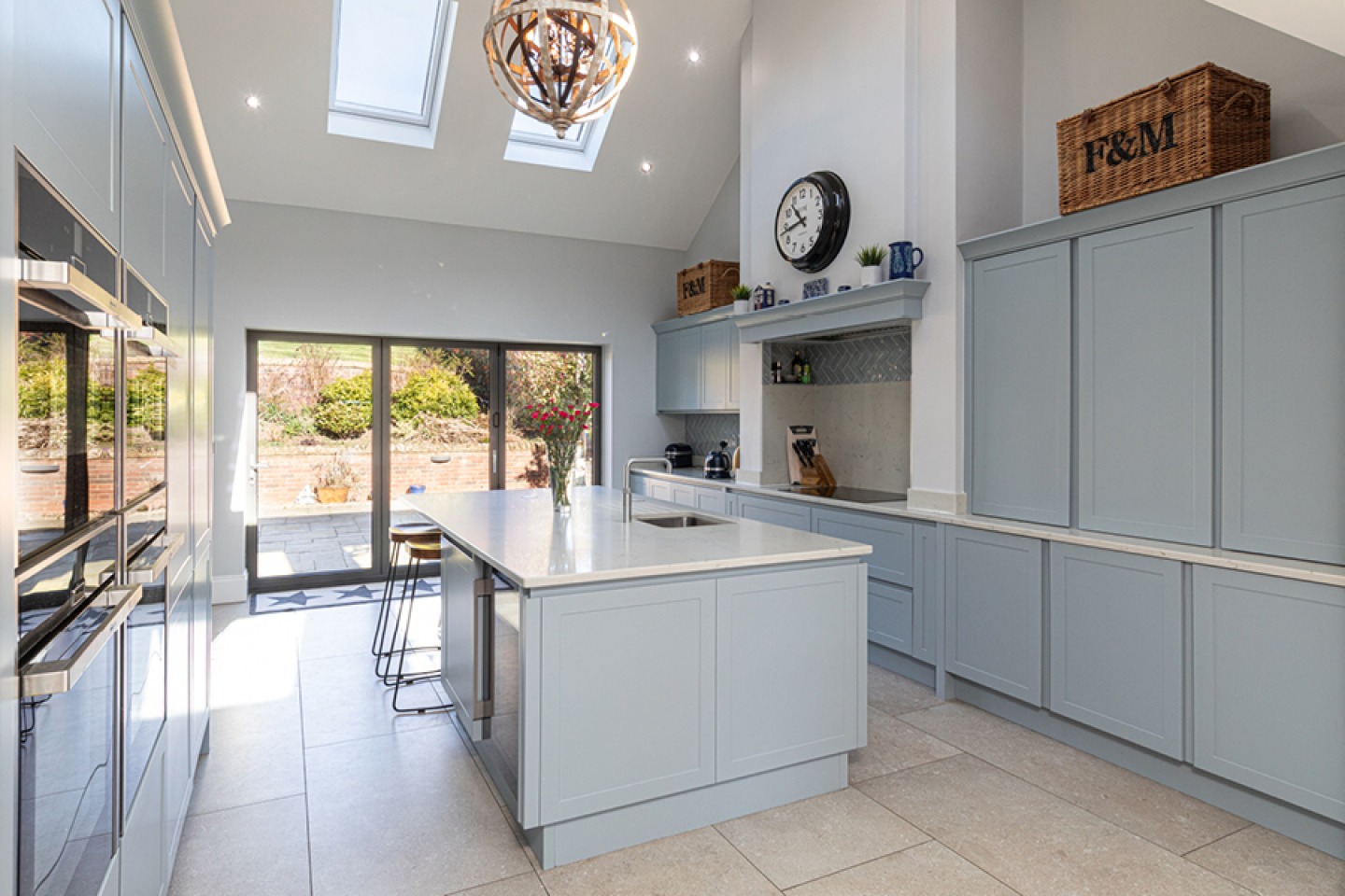 Contemporary sheer style kitchen in blue/grey with vaulted ceiling and feature orb light