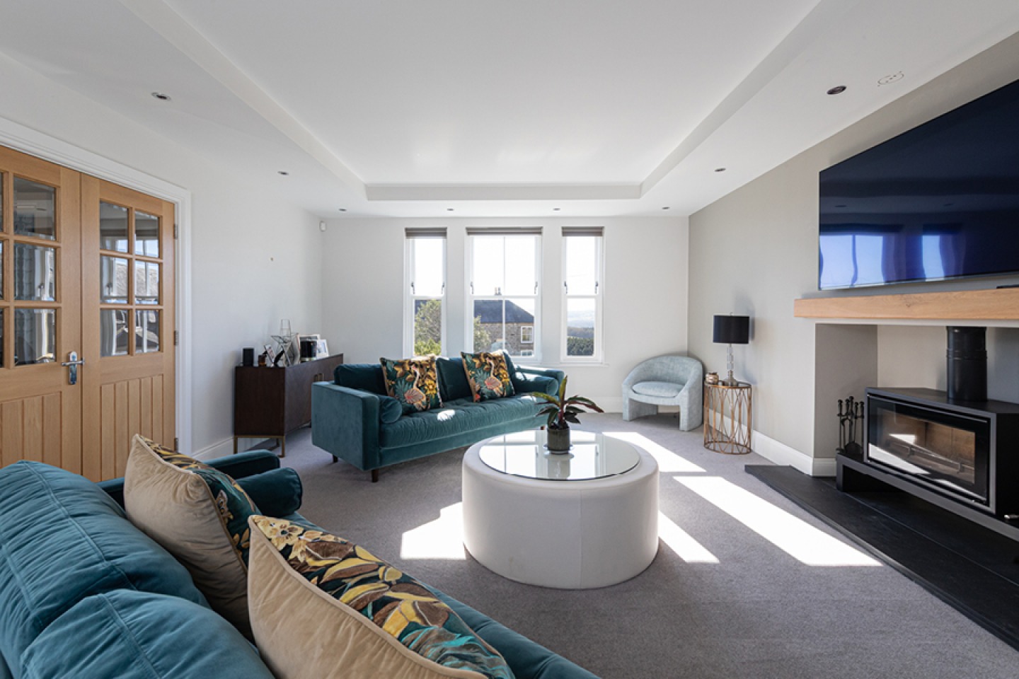 Modern lounge with blue sofas and wood burning stove
