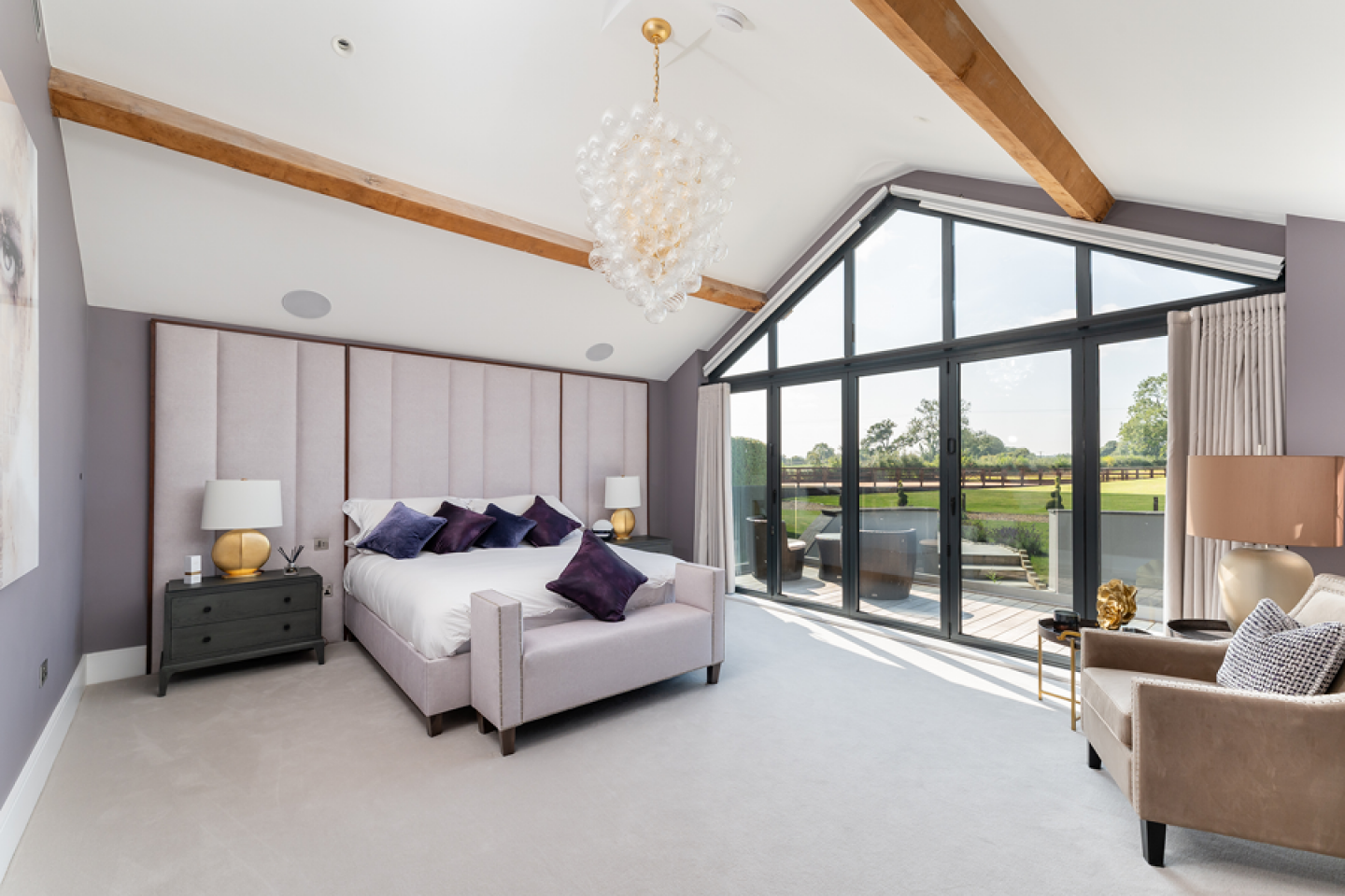 modern master bedroom with floor to ceiling glass doors to a terraced area