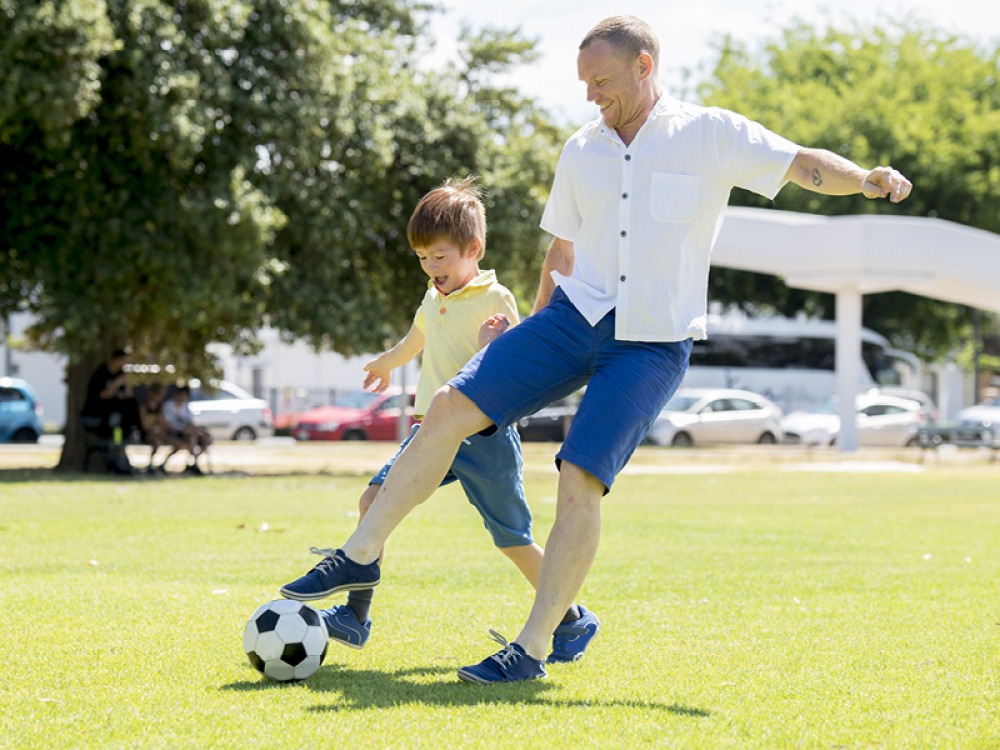 man and boy playing football