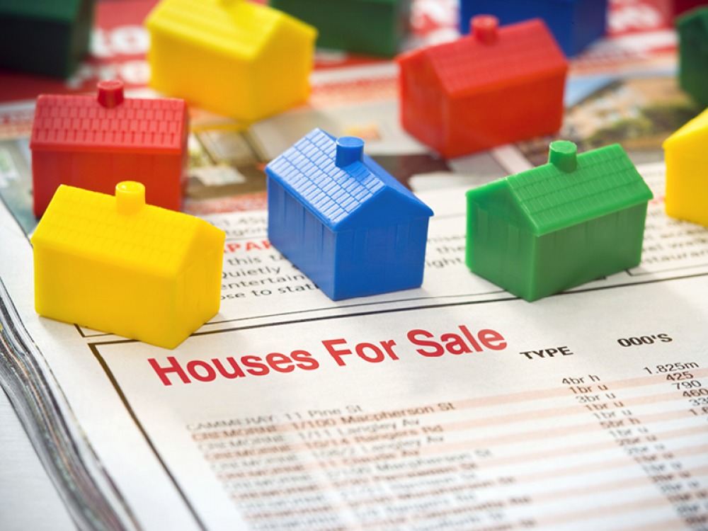plastic coloured houses sitting on a news paper