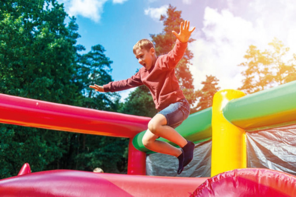 Boy jumping on inflatables at William’s Den, Hull