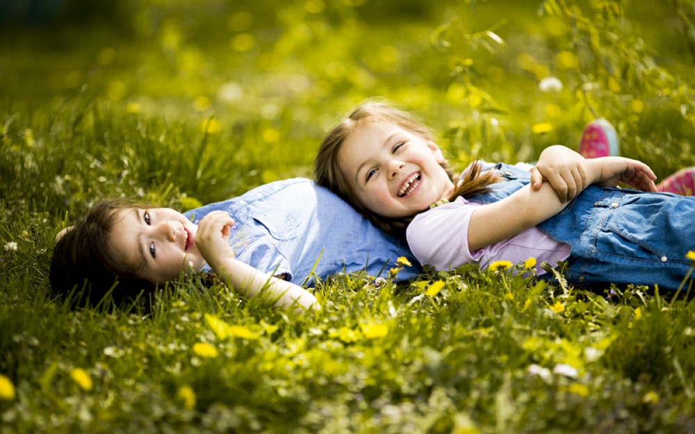 kids lying in grass in spring