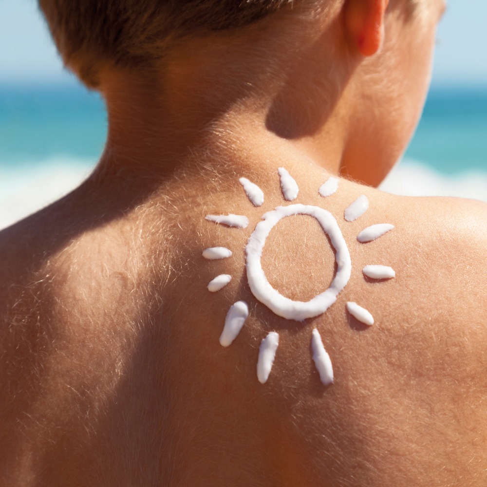 child with sun cream sunshine drawn on his back