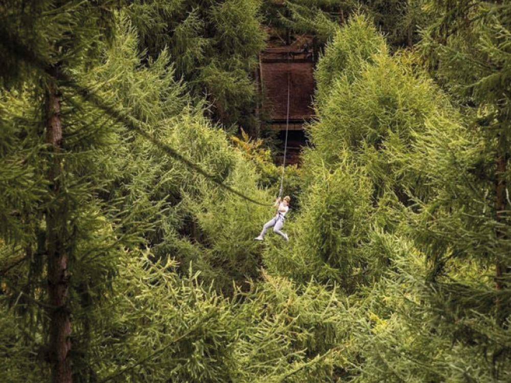 Girl zip lining at Dalby Forest