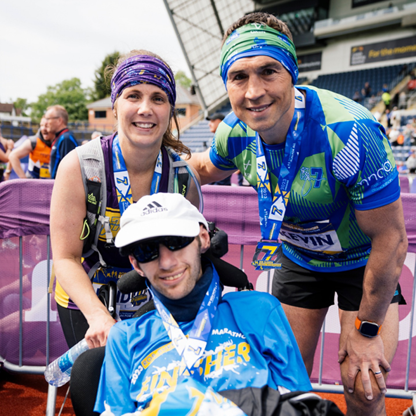 Rob in his chair, Kevin and a woman ready to run a marathon