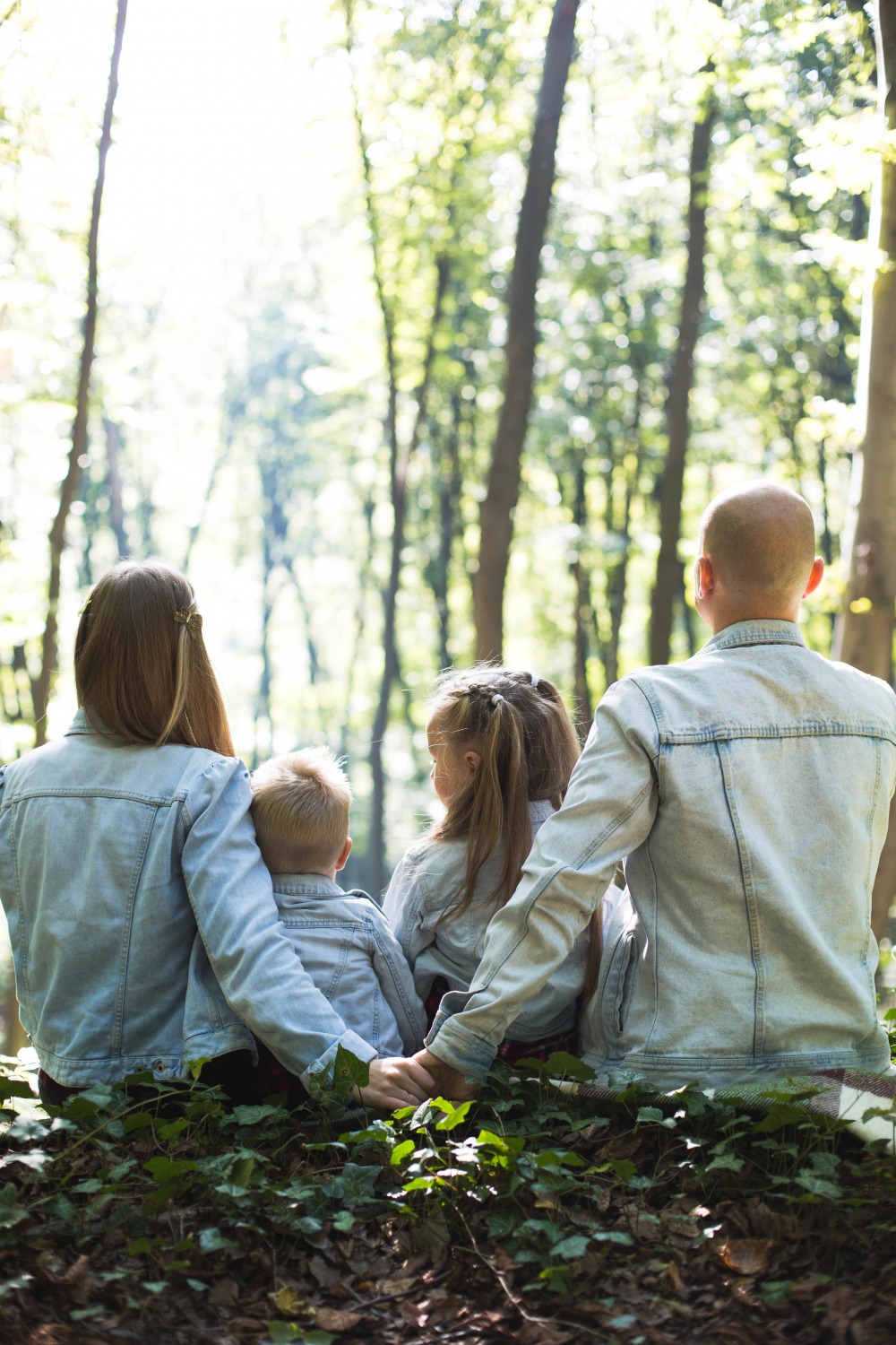 Mum and dad holding had with backs towards with their arms around their daughter and son