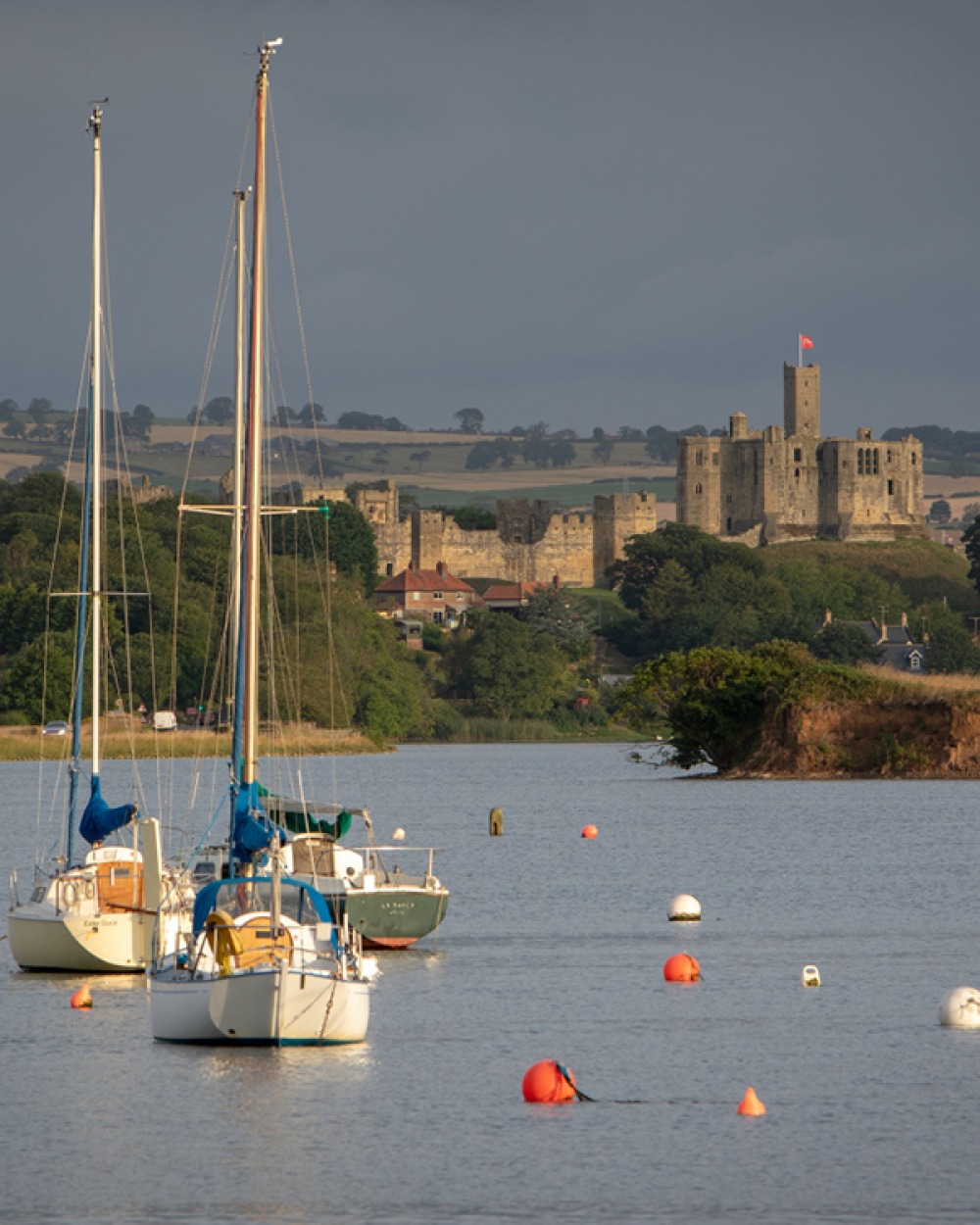 Boats on the water with Warkworth Castle in the background