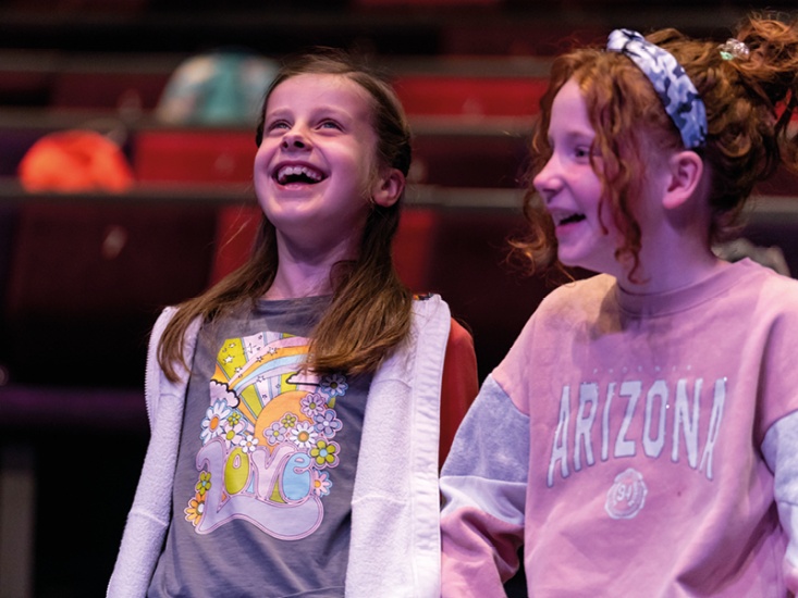 2 girls laughing in a theatre