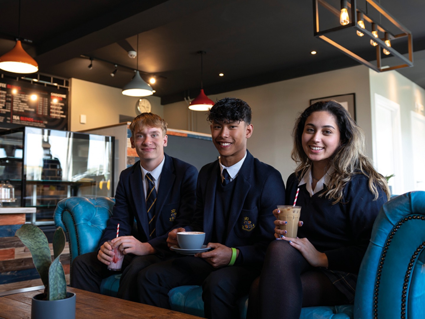 3 students sitting together in a cafe