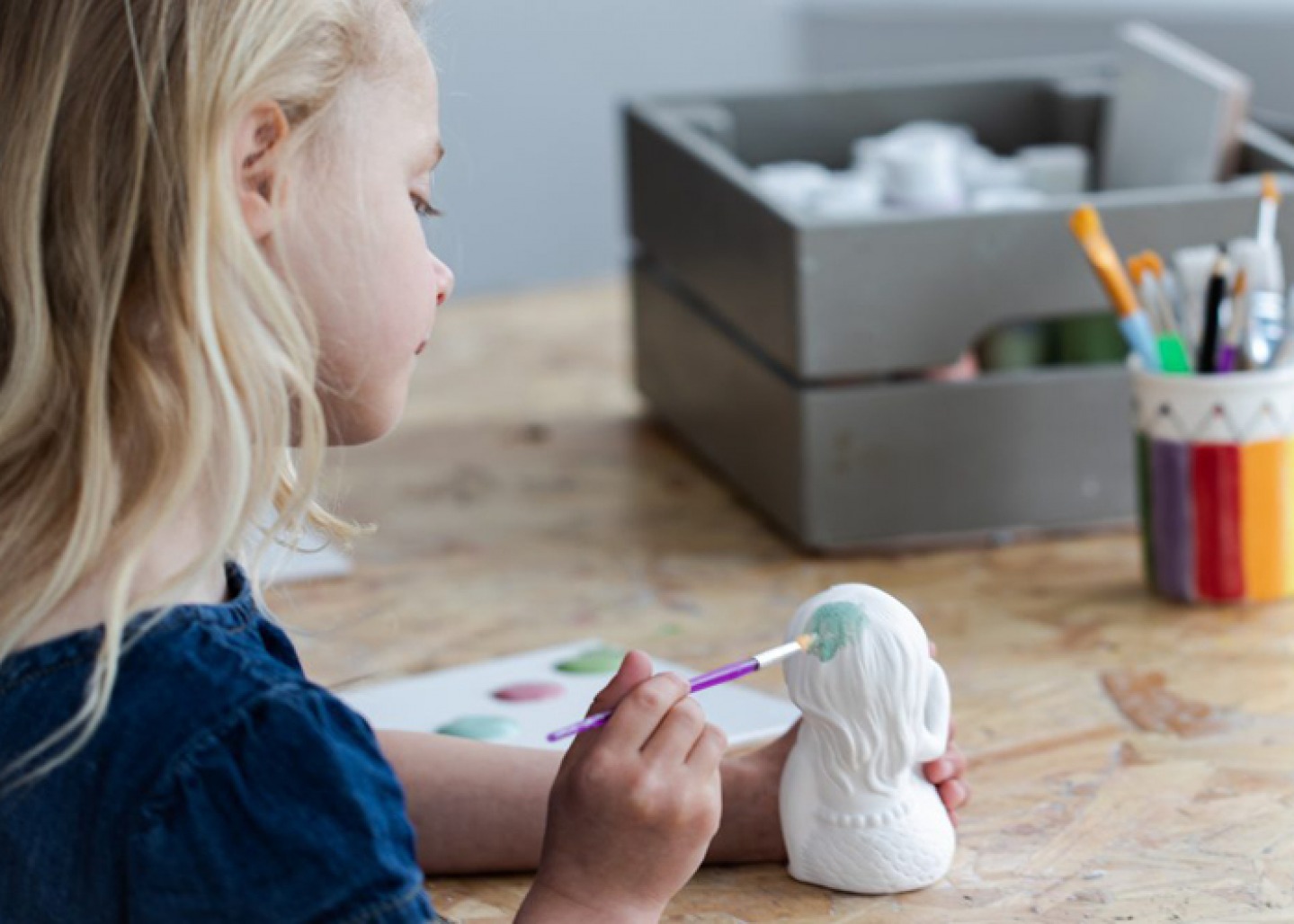 Young girls painting pottery