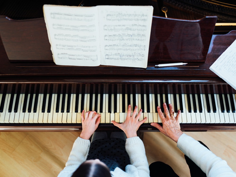 teacher and pupil playing piano