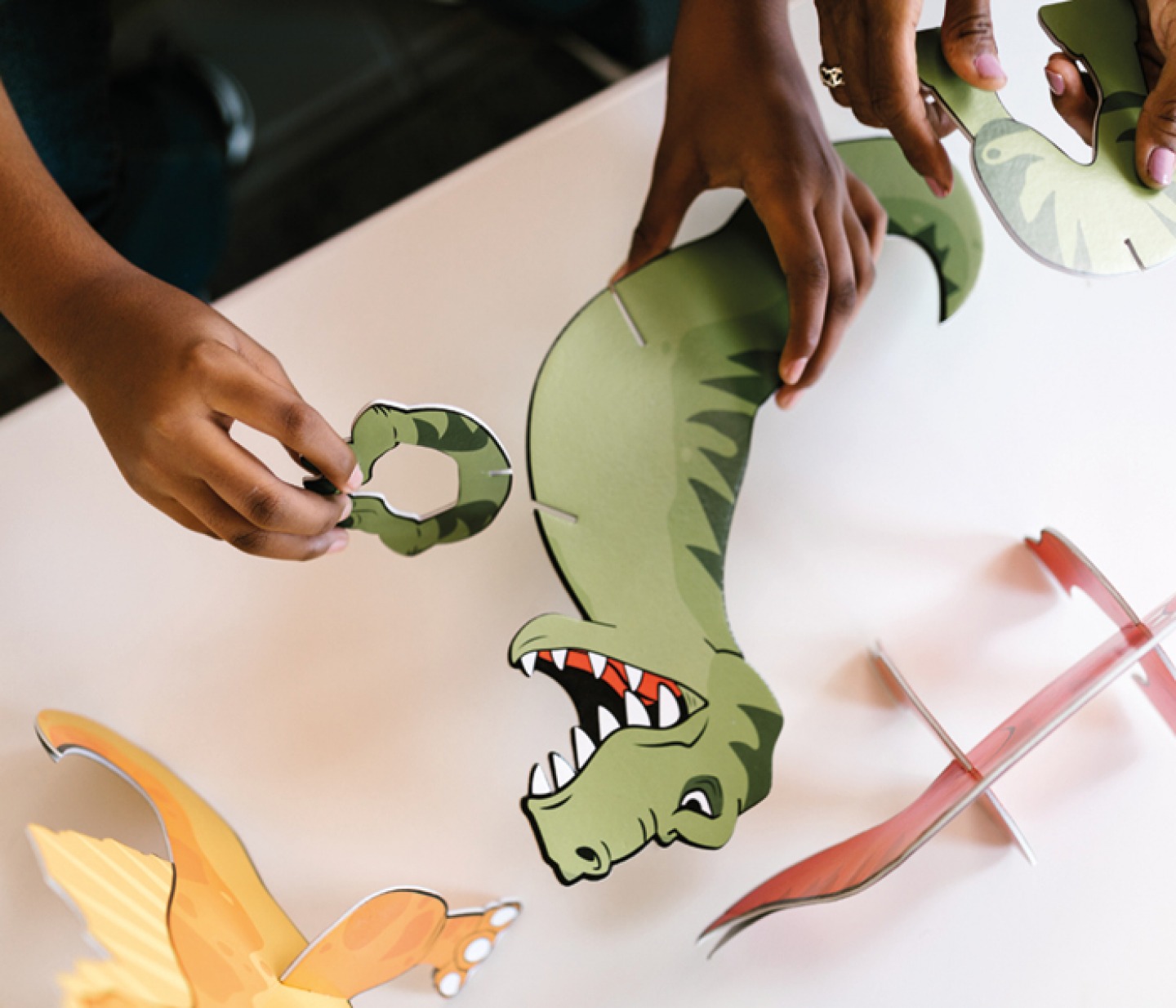 Child building a paper Dinosaur