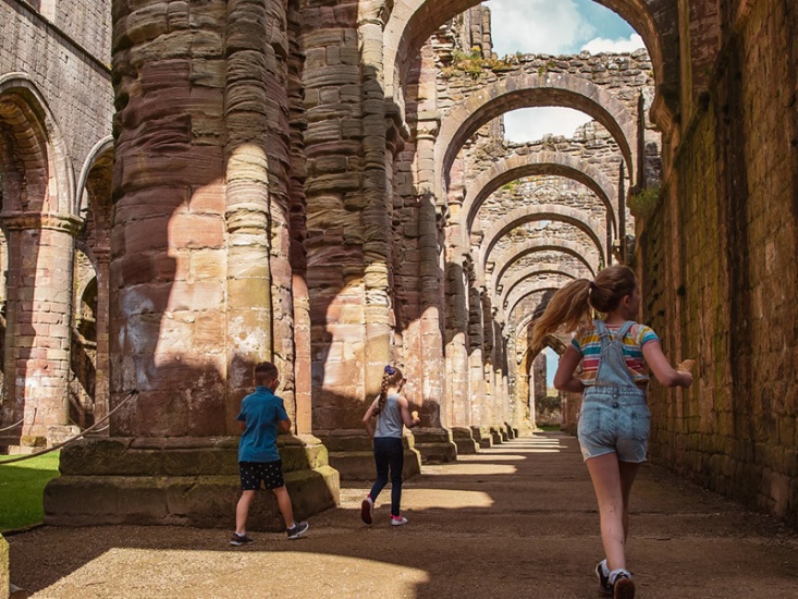 children exploring the columns of the abbey nave in the summertime © J Shepherd