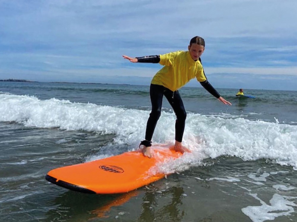 Girl learning to surf in shallow water