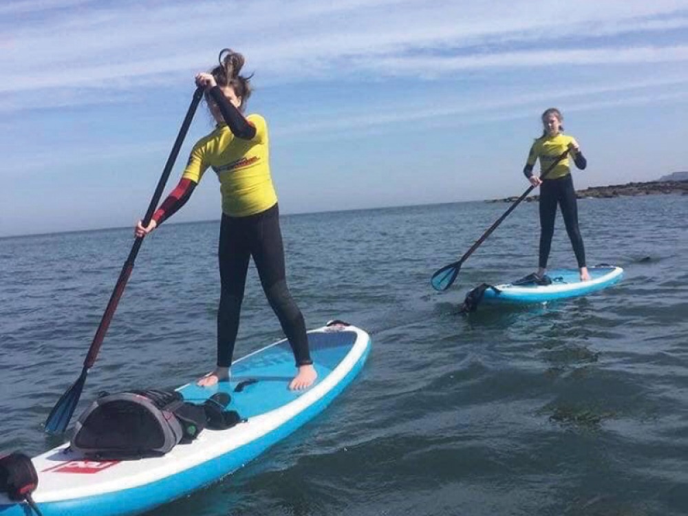 2 girls paddle boarding