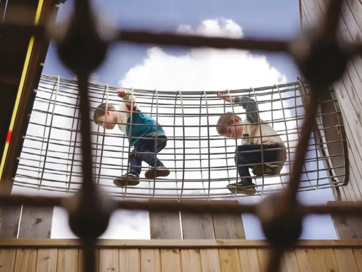 Kids climbing through rope tunnel
