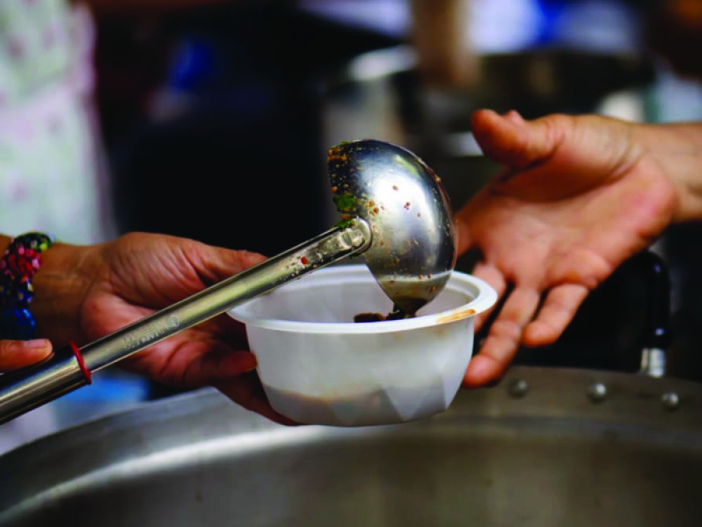a person serving food and passing to another