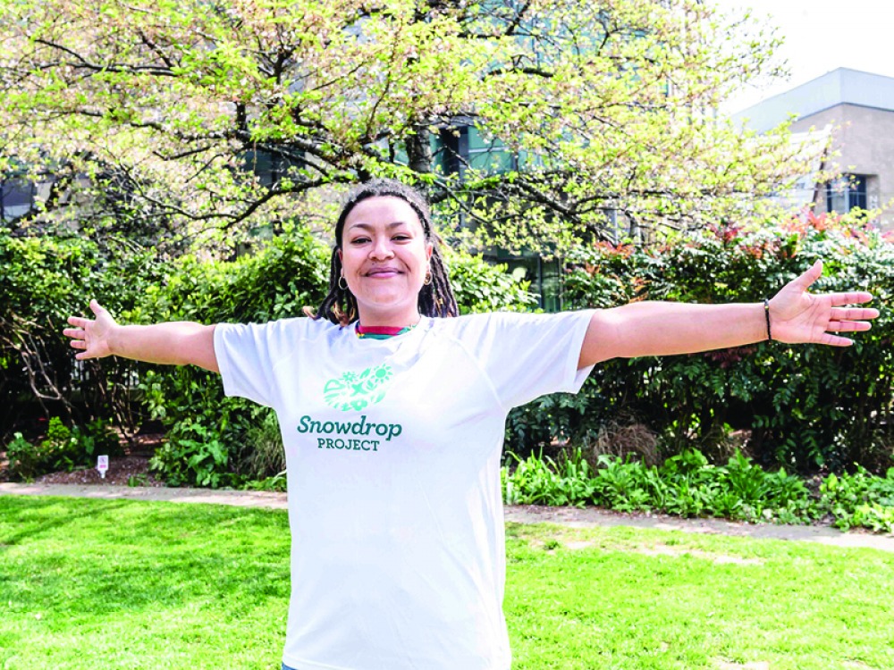 woman standing with her arms out wearing a charity t-shirt