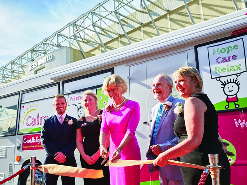 A woman wearing pink cutting an opening ribbon