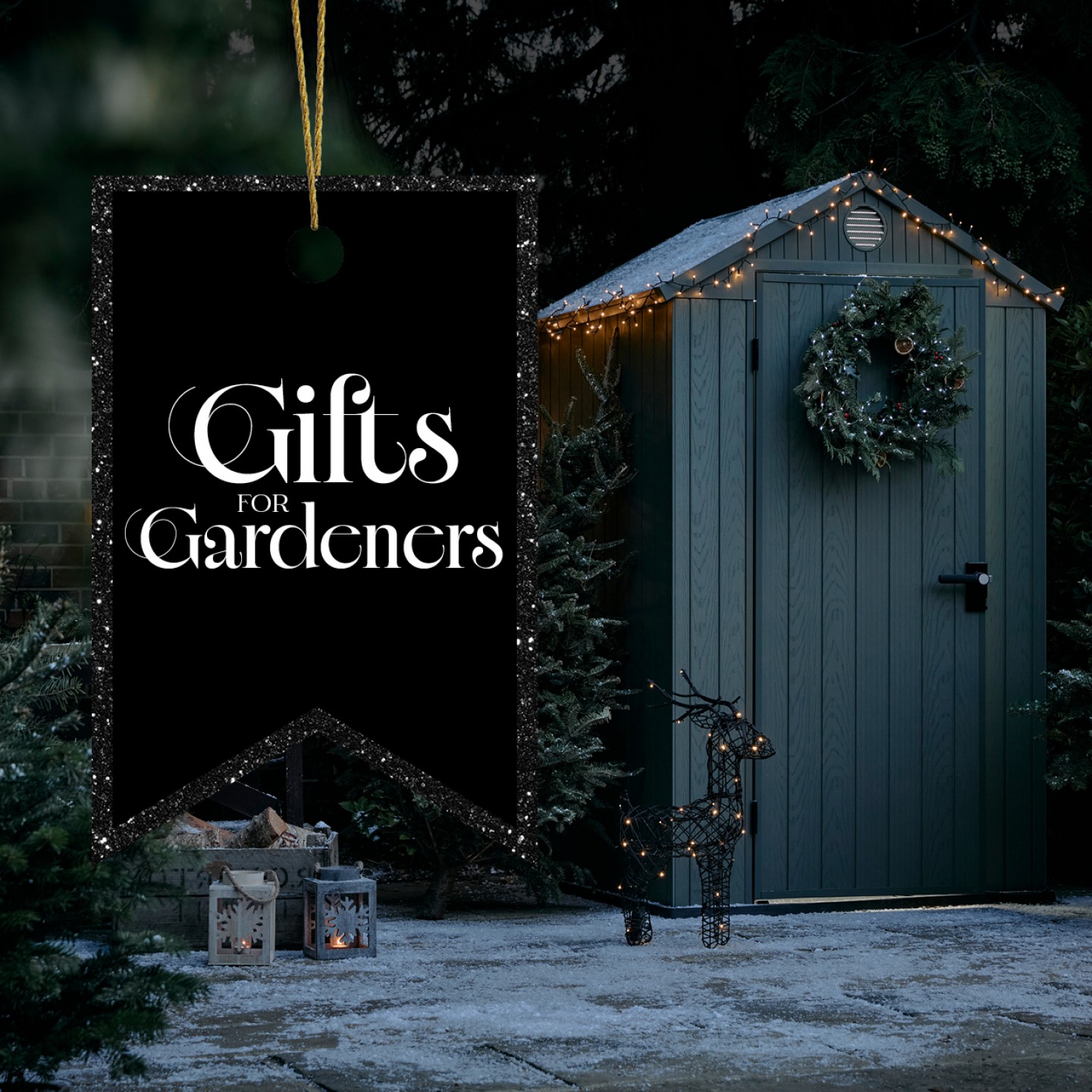 Garden shed in Winter with snow fall, wicker reindeer and Christmas lights
