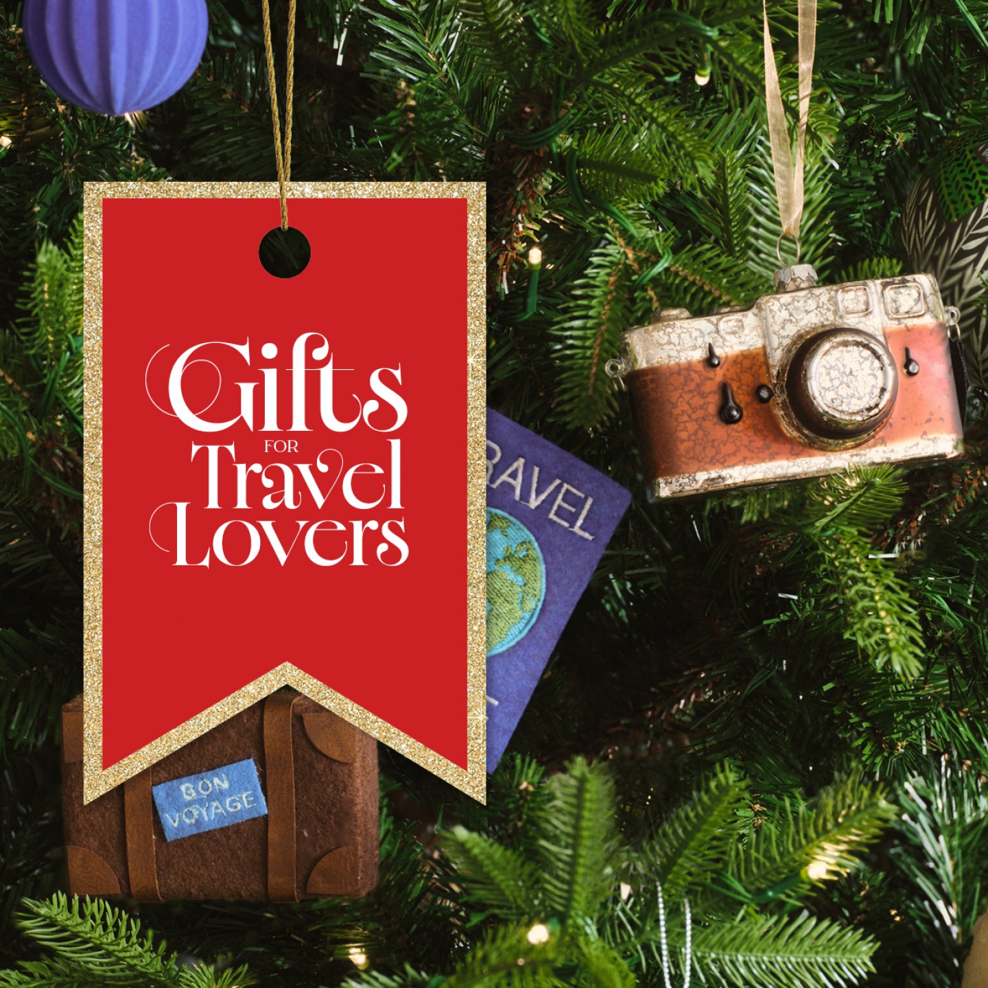 Suitcase, Travel Journal and camera Christmas ornaments hanging on a tree
