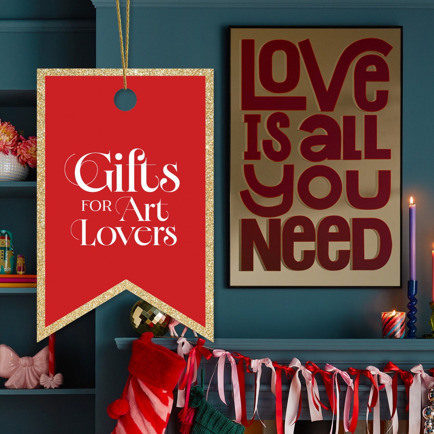 'Love is all you need' artwork hung on chimney breast with christmas decorations around the fireplace