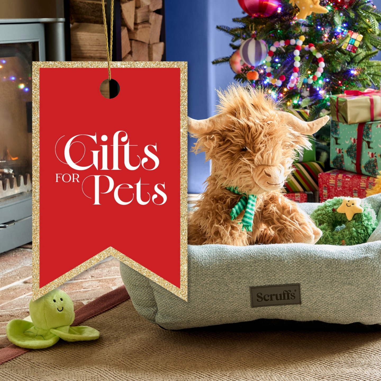 Highland cow teddy in a dogs bed with Christmas tree in background