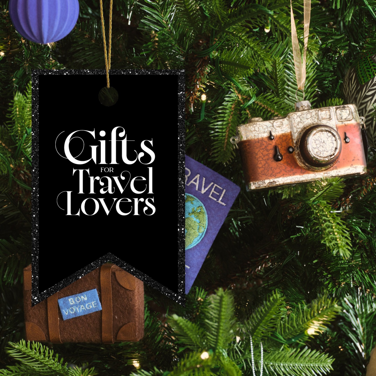Suitcase, Travel Journal and camera Christmas ornaments hanging on a tree