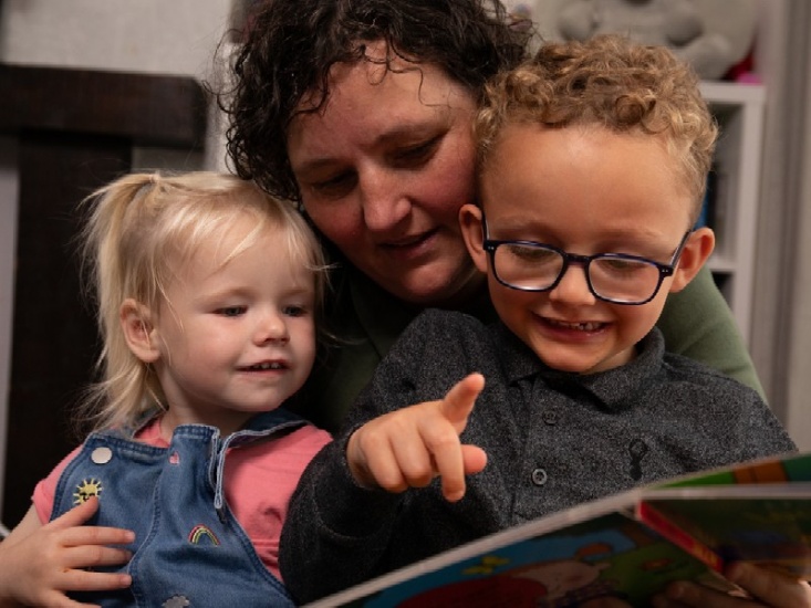 Foster mum reading to two young children