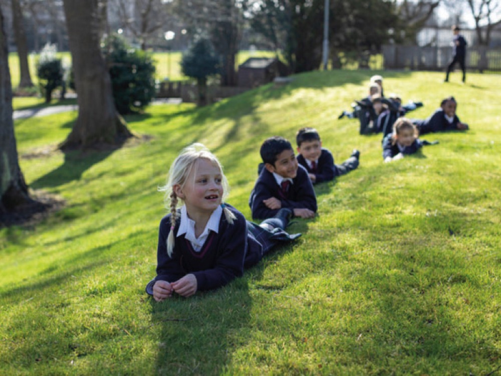 young students lying on the grass