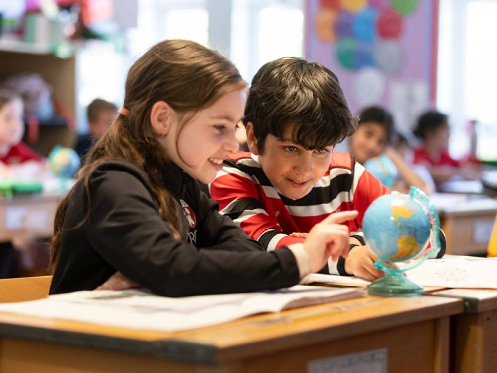 Students looking at a a small Globe