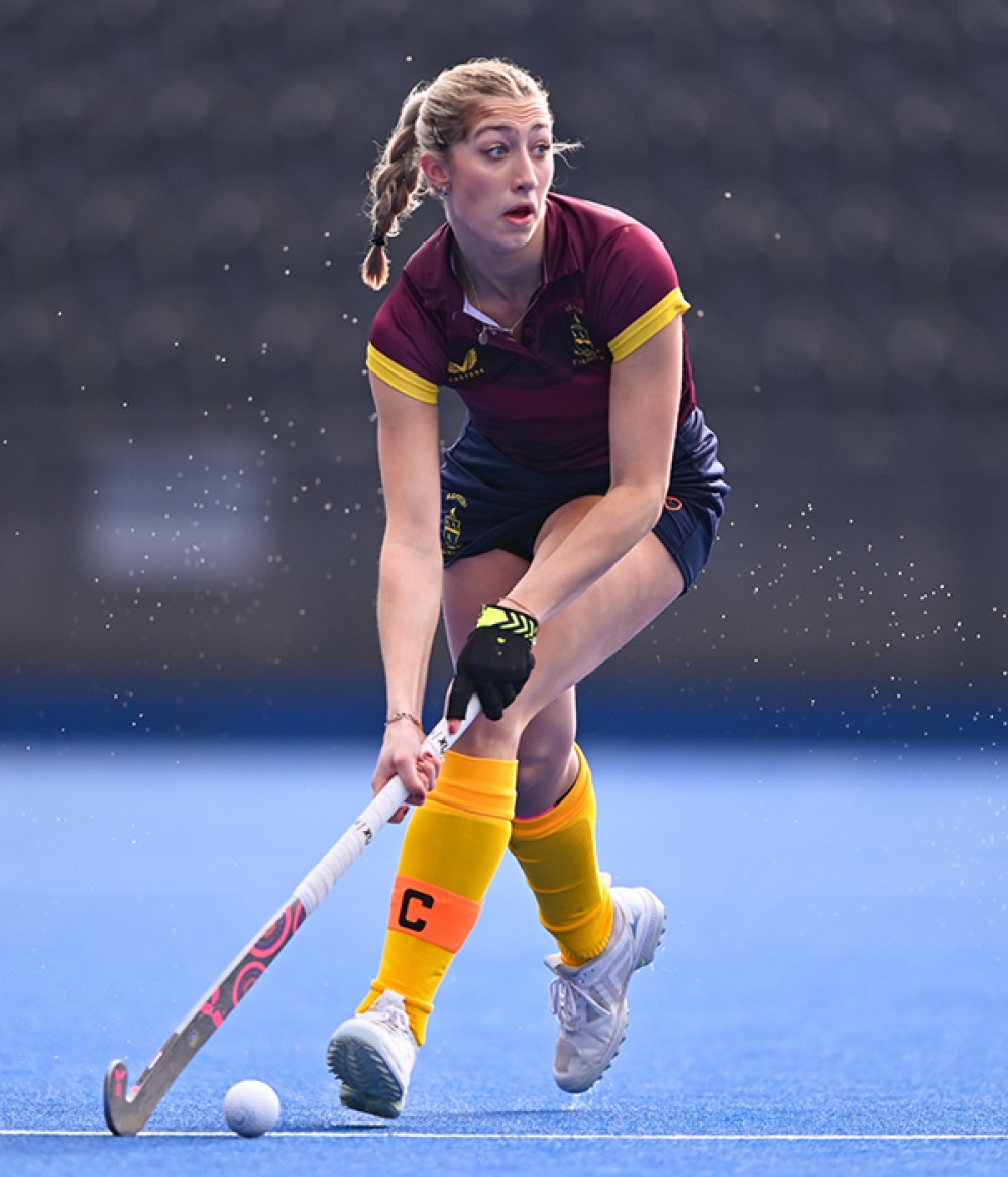 Action shot of a female student playing field hockey