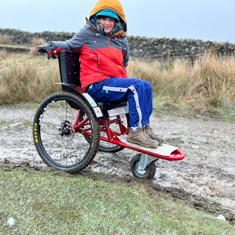 lady using her wheelchair on a walk in mud