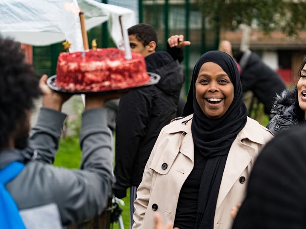 lady smiling at a surprise cake