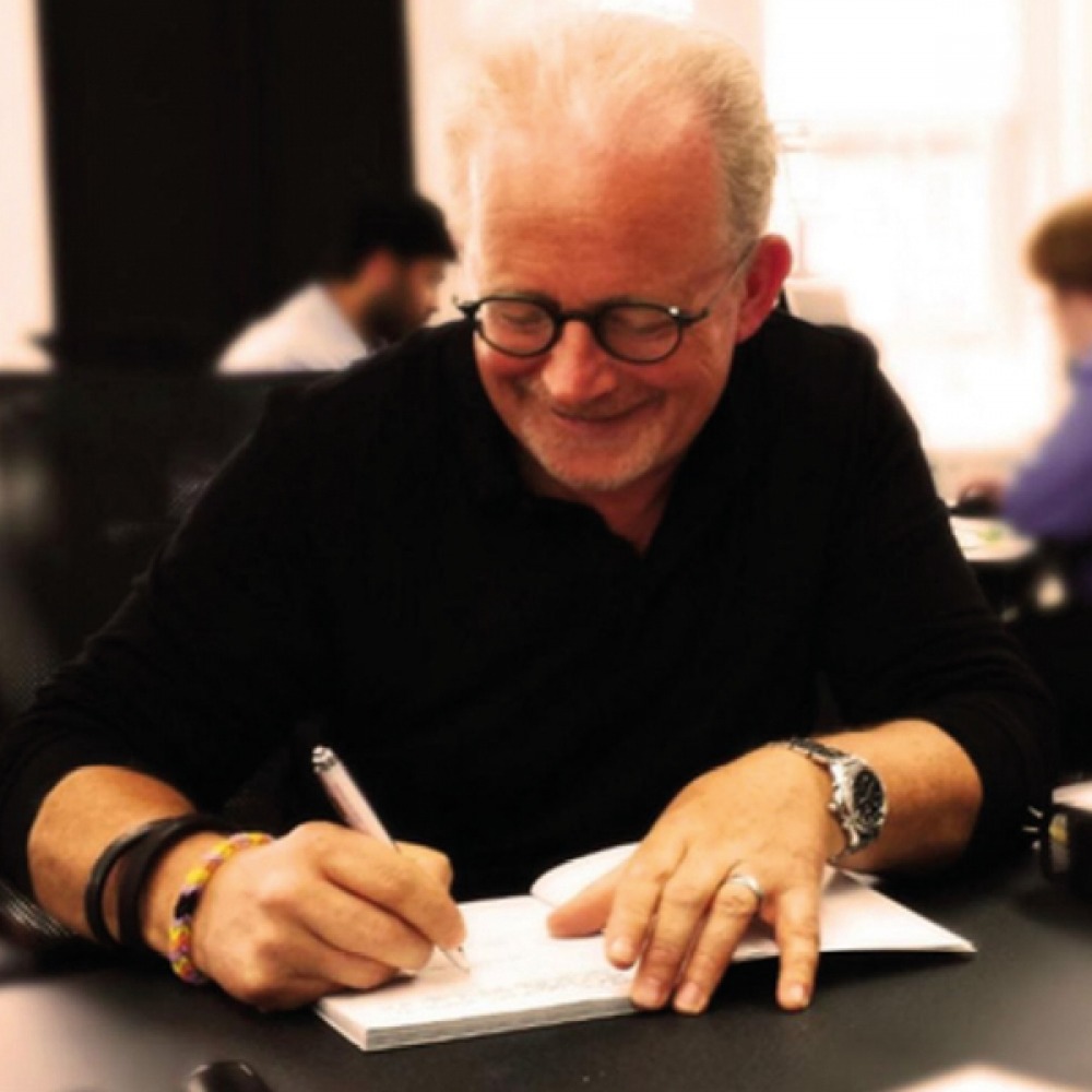 man writing in a journal