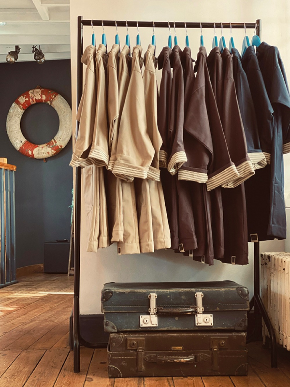 clothes rack with beige, brown and blues coats hanging