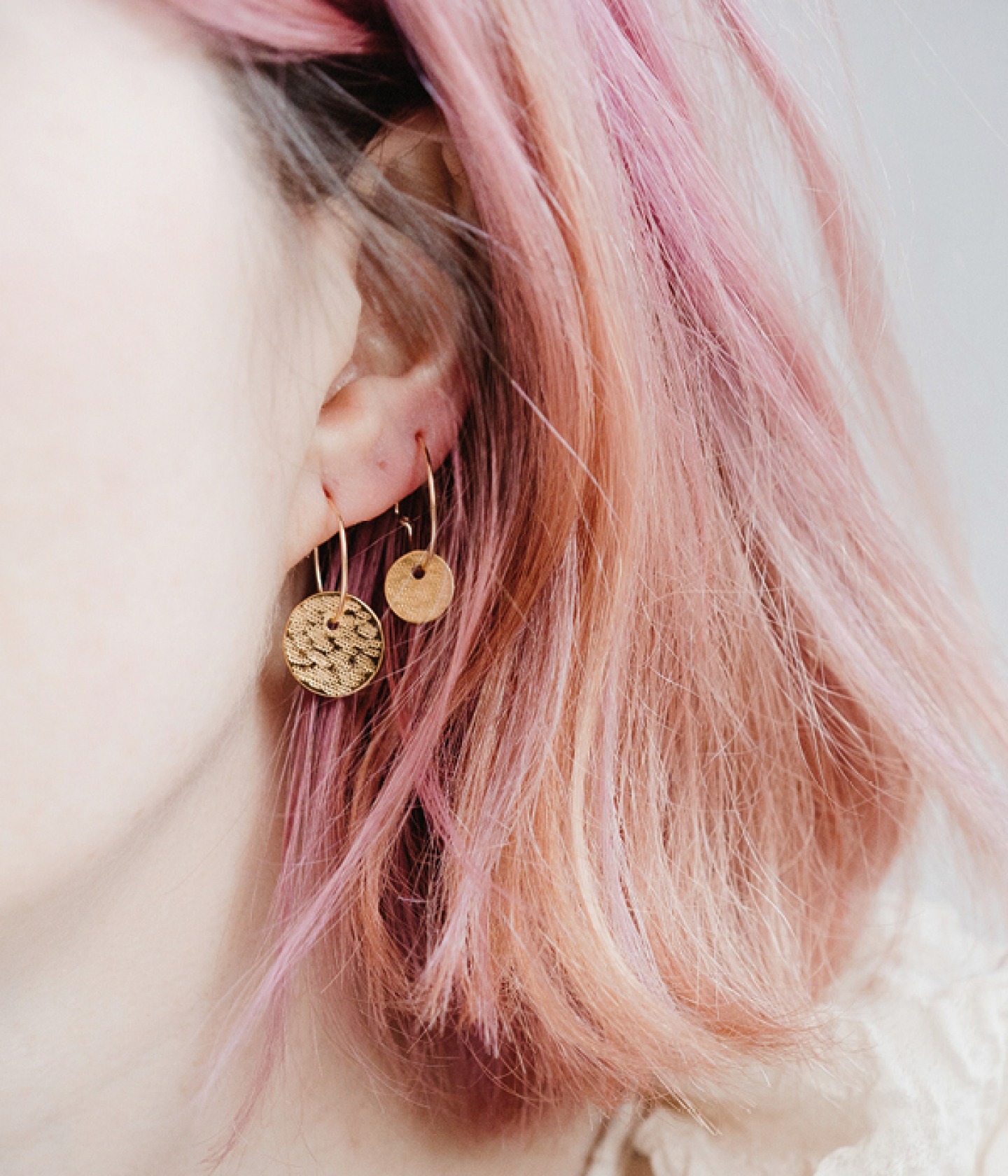 close up of an ear wearing 2 earrings