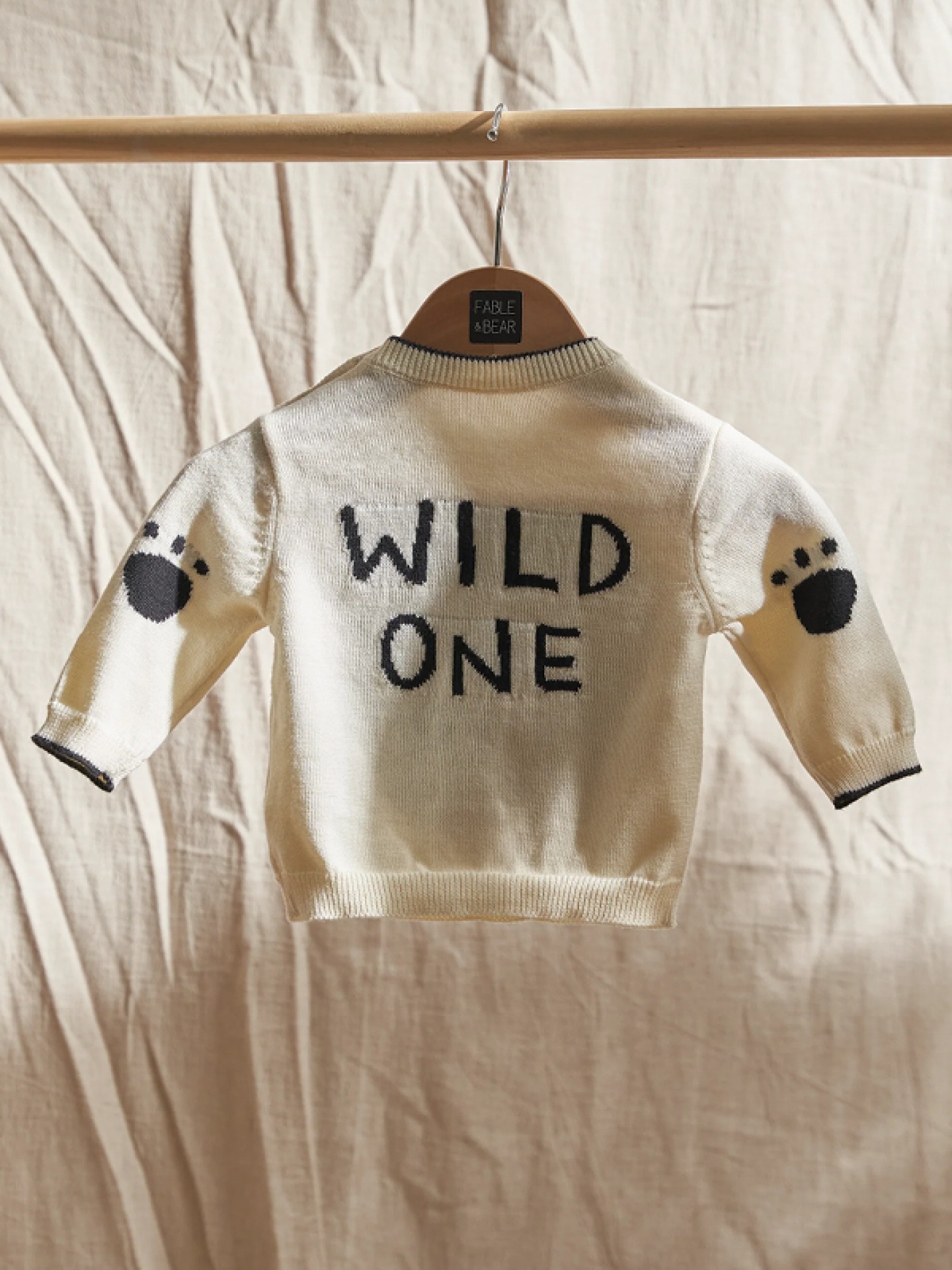 Back of a cream knitted jumper with Wild One slogan and paw prints