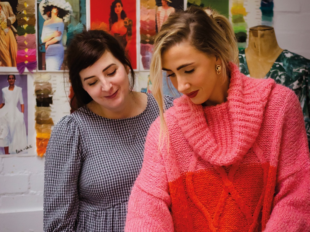 2 woman looking down smiling