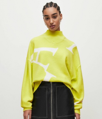 model wearing a yellow jumper with a black skirt