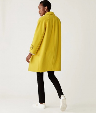 model wearing a long yellow wool coat with black jeans