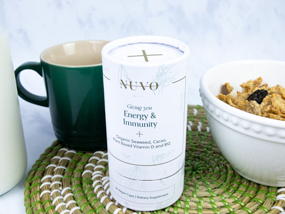 Tube of vitamins on a wicker mat alongside a bowl of cereal and mug