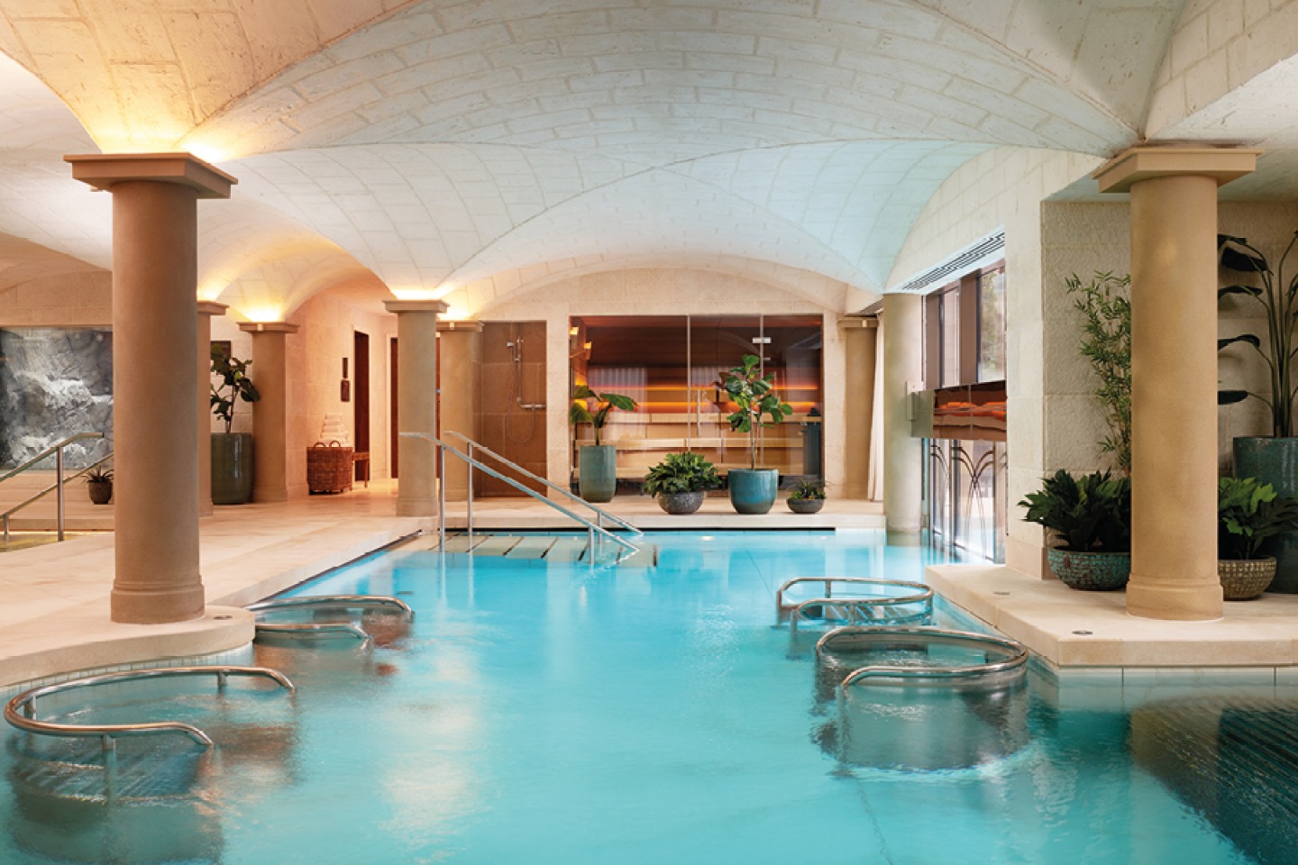 Indoor swimming pool with jacuzzi pods, pillars and concave ceiling