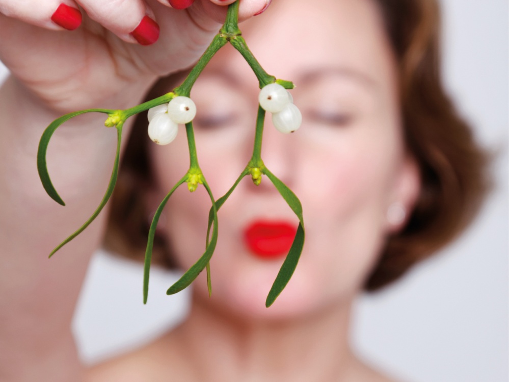 woman wearing red lipstick holding Mistletoe